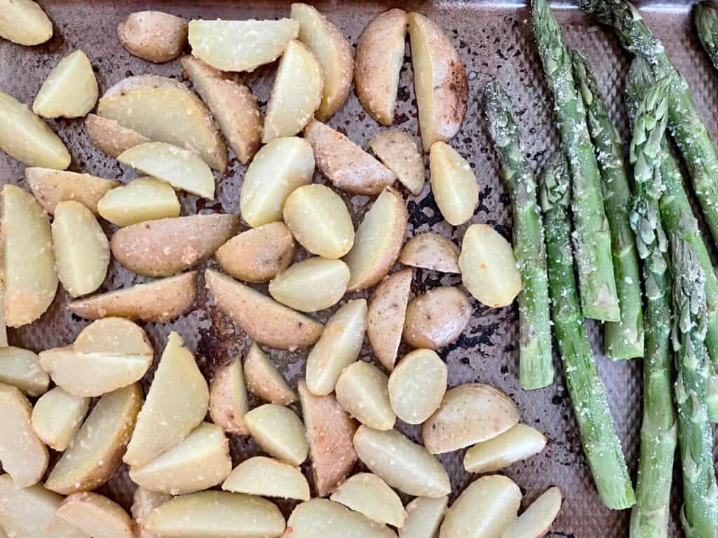 Sheet pan containing both the potatoes and the asparagus.  Ready to go back in the oven and cook for 15 minutes more.