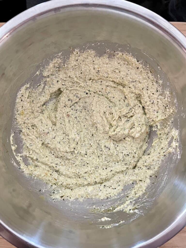 Ricotta cheese, basil pesto and 1 egg combined in a mixing bowl for pesto turkey meatballs with ricotta cheese