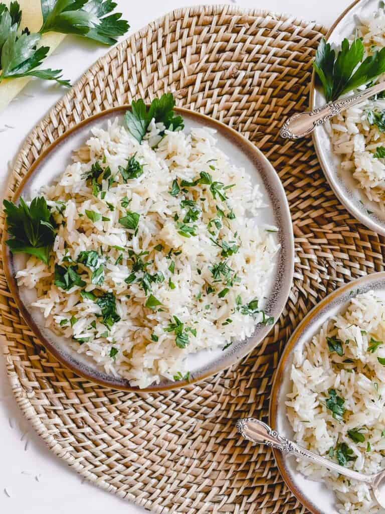 Garlic basmati rice displayed on a grey/brown plate. Garnished with fresh flat leaf parsley.