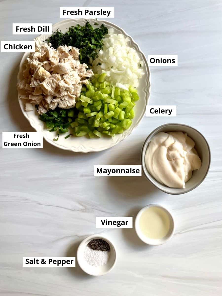 Ingredients in chicken salad displayed on a surface. The ingredients are all labeled. 