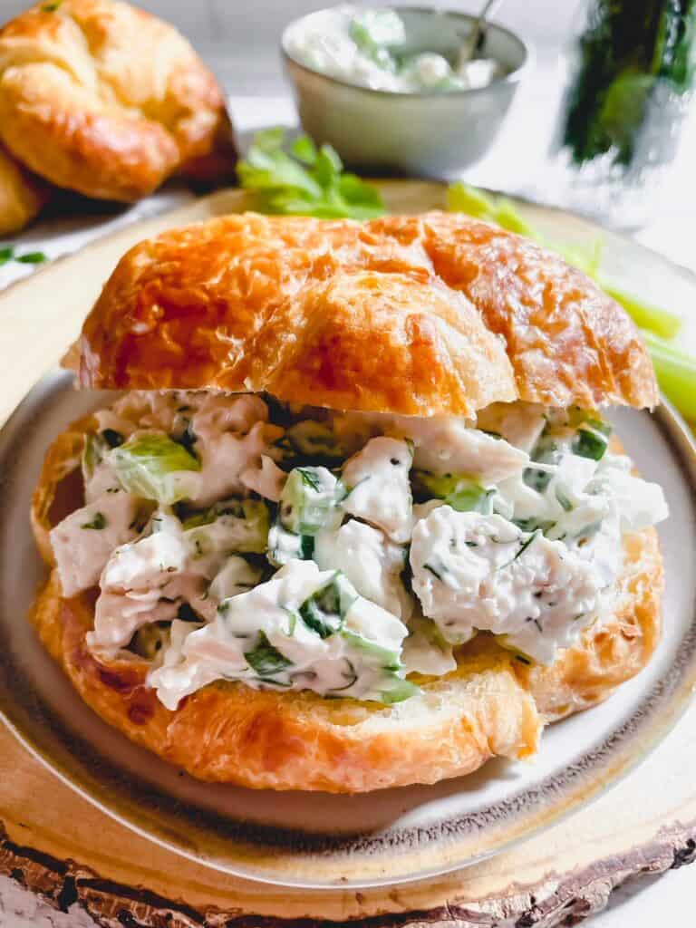 Up close view of a classic chicken salad sandwich on a croissant bun,