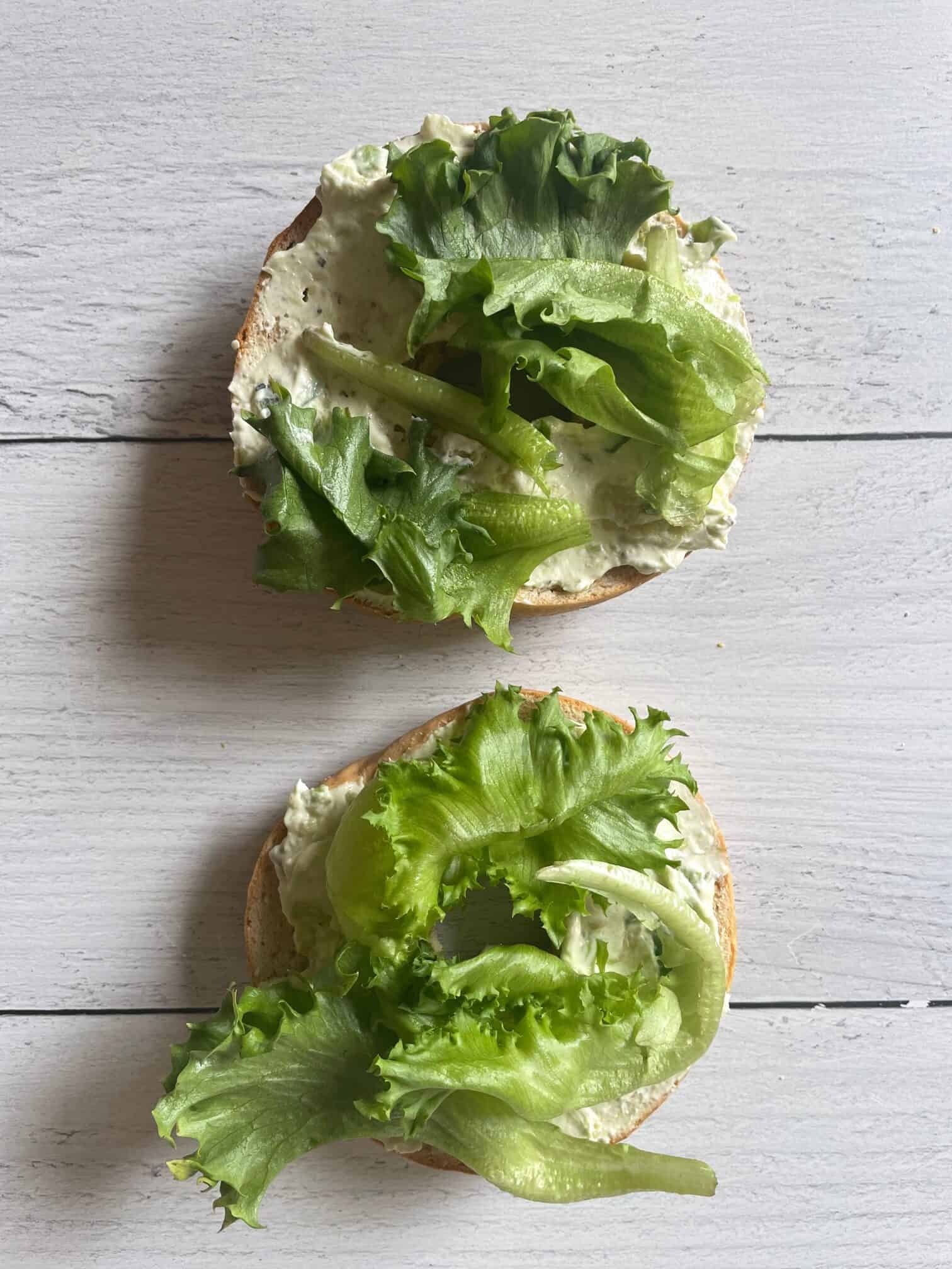 Bagel with cream cheese and lettuce.