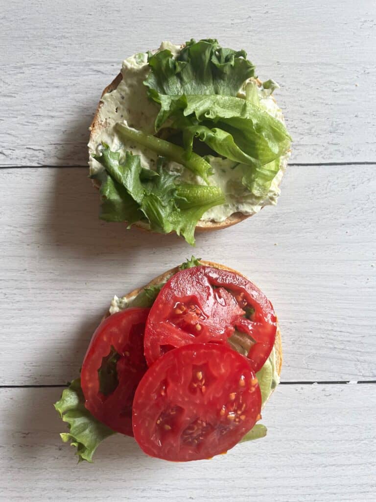 Bagel with cream cheese, lettuce and tomato.