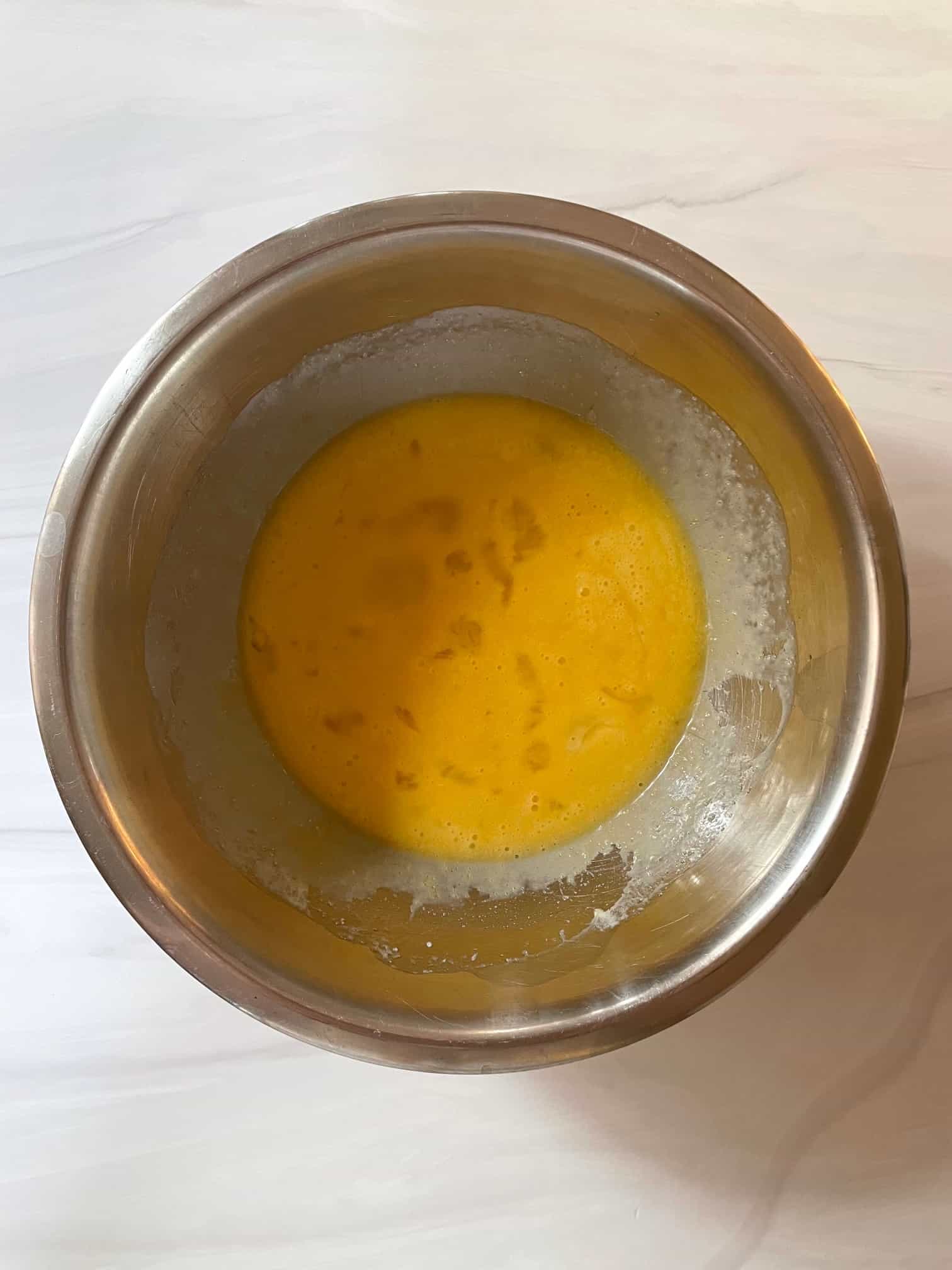 Egg, sugar, melted butter, salt and vanilla extract mixed together in a stainless steel bowl