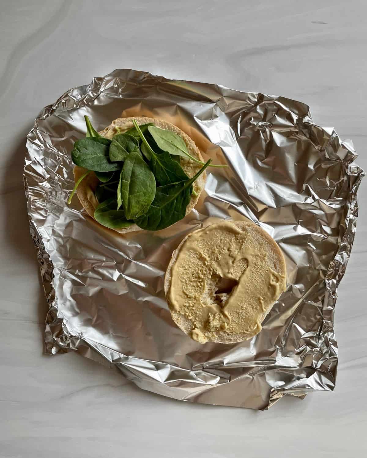 Open bagel on foil with spinach and Dijon mayo.