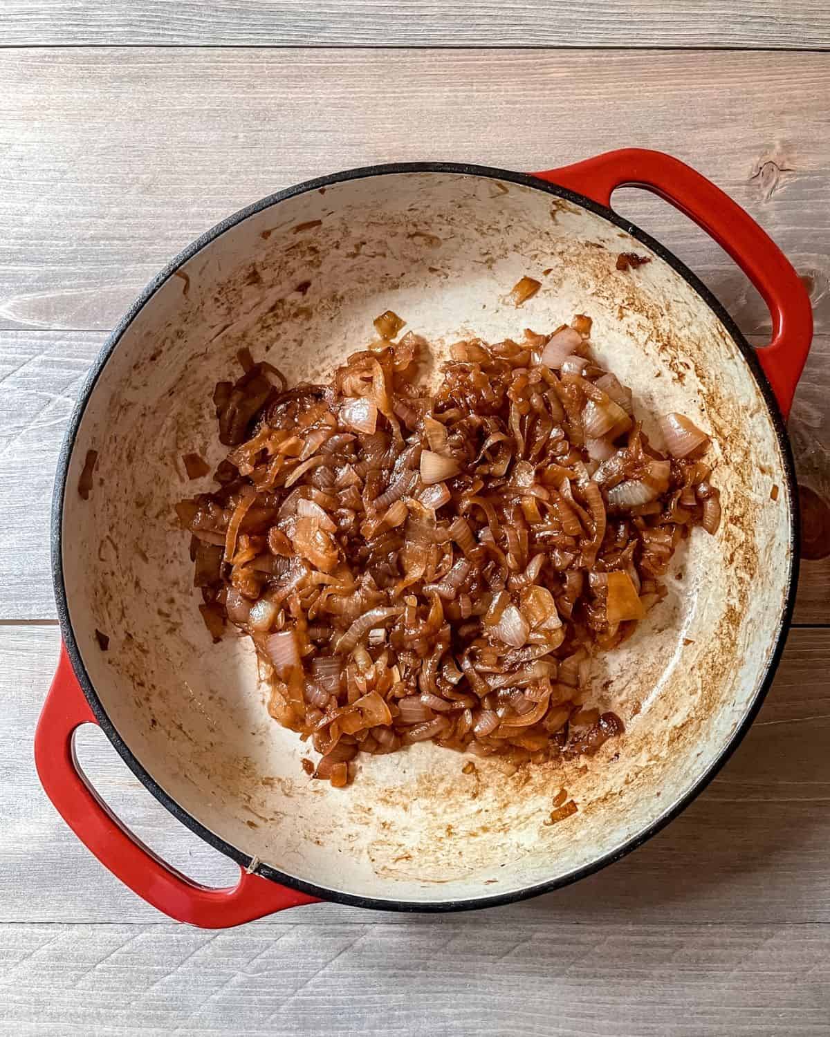 Caramelized onions in a red skillet.