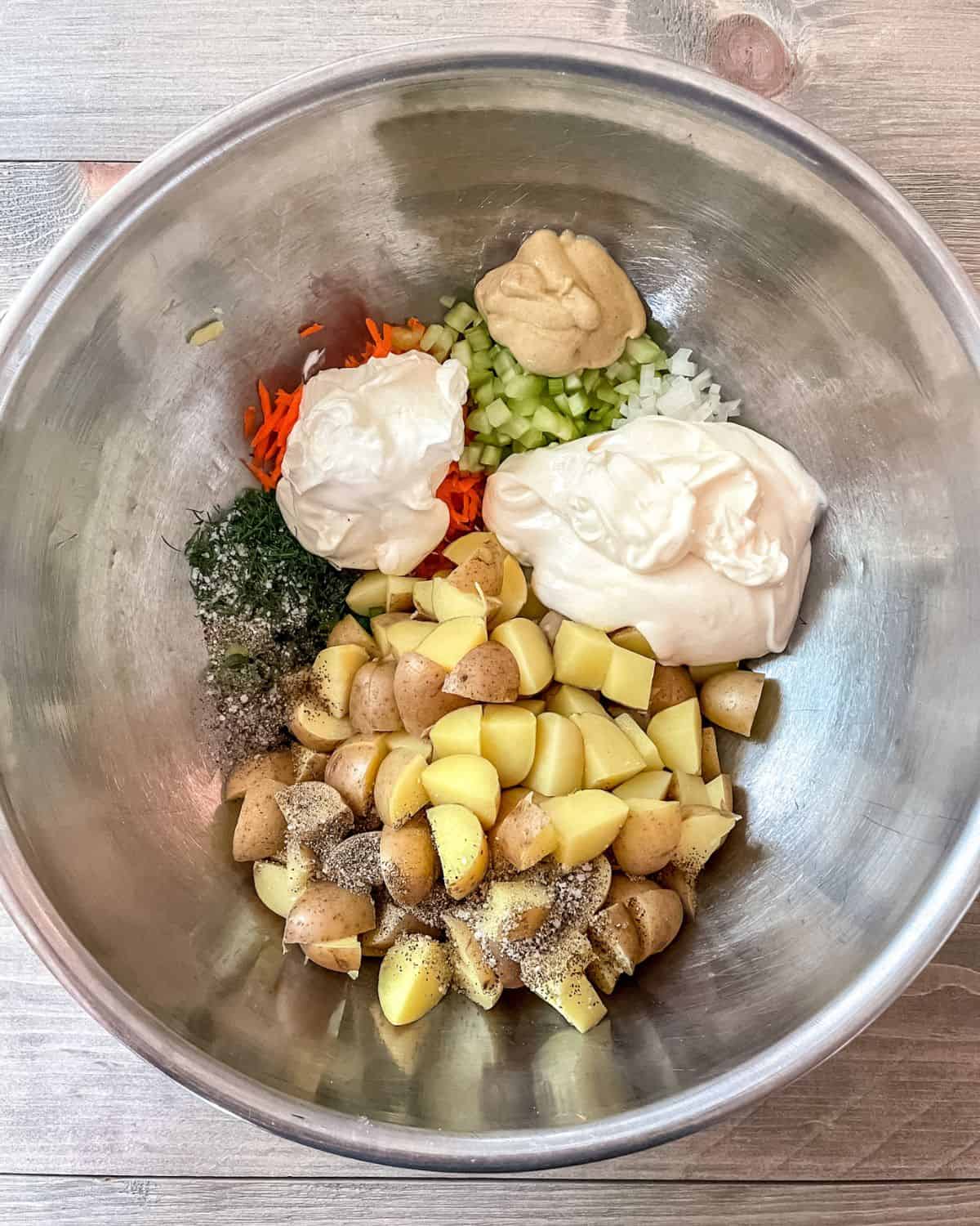 Potato salad ingredients unmixed in a large stainless steel bowl.