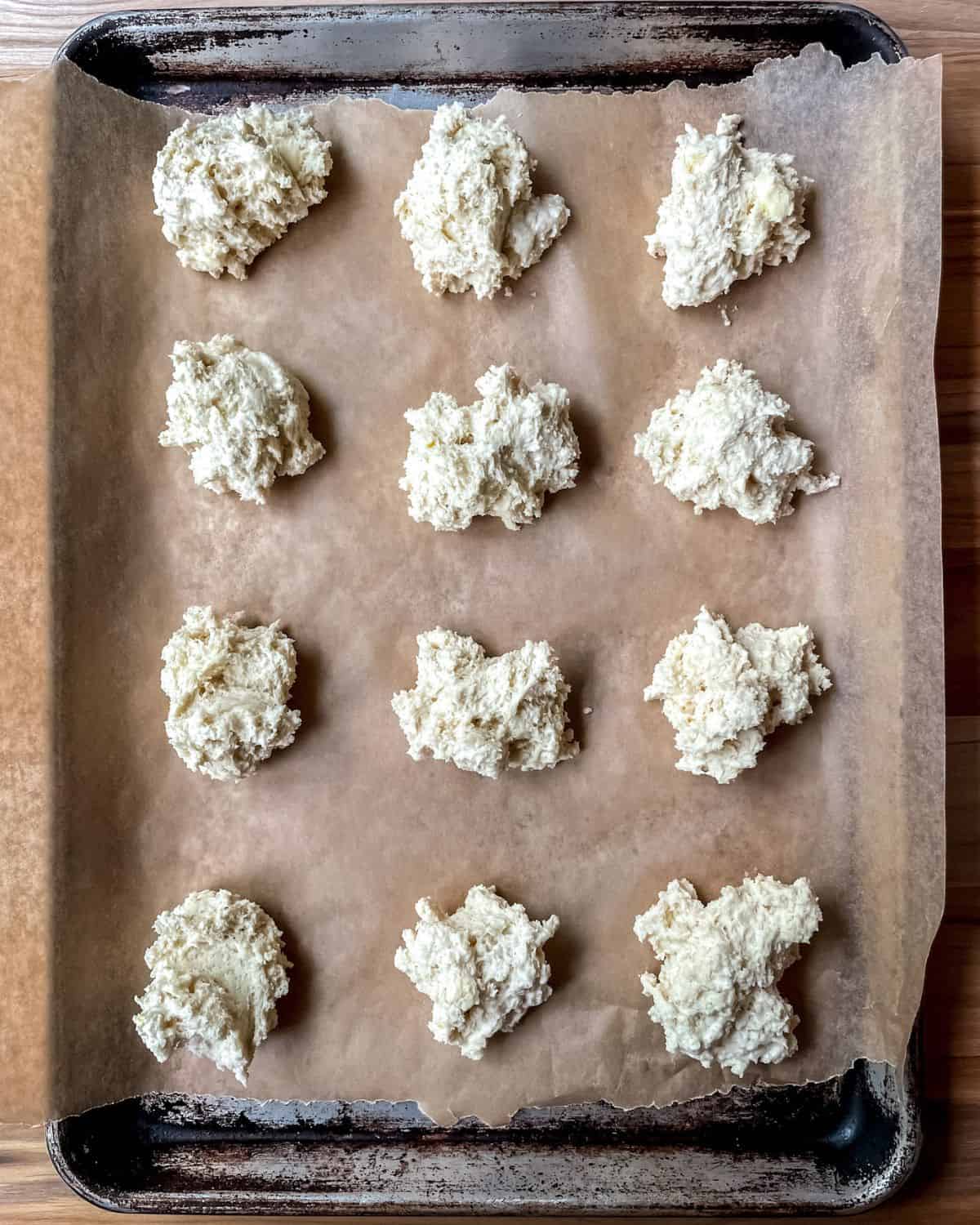 Drop biscuits on a parchment lined baking sheet, uncooked.