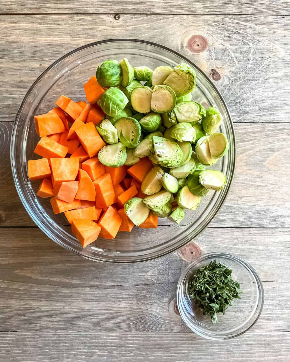 Chopped vegetables and chopped herbs in glass bowls.
