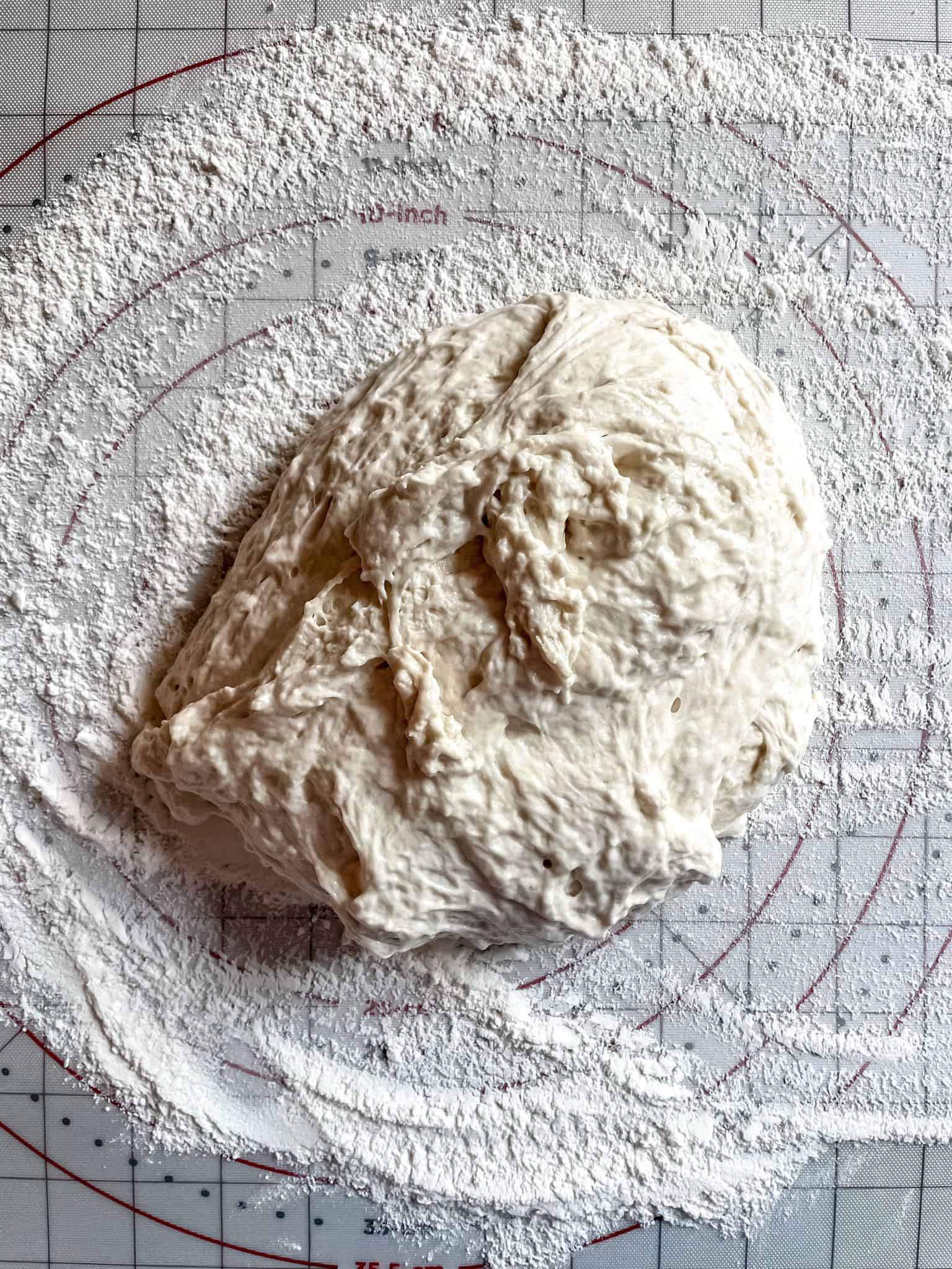 Raw bread dough on a floured surface.