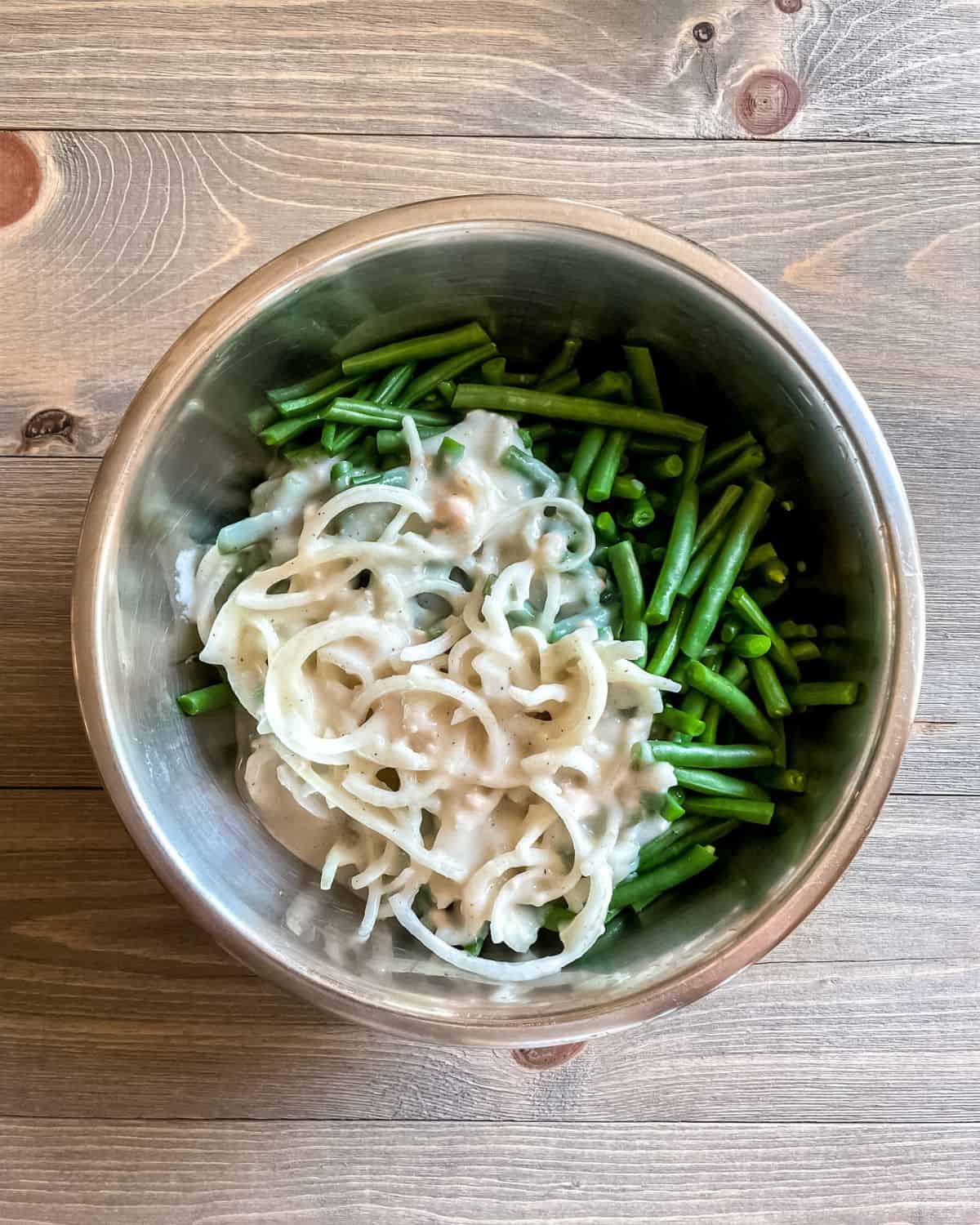Blanched green beans and cream of chicken soup mixture in a bowl.