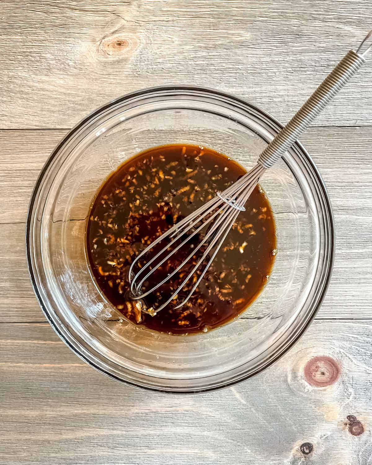 Sauce ingredients whisked together in a glass bowl.