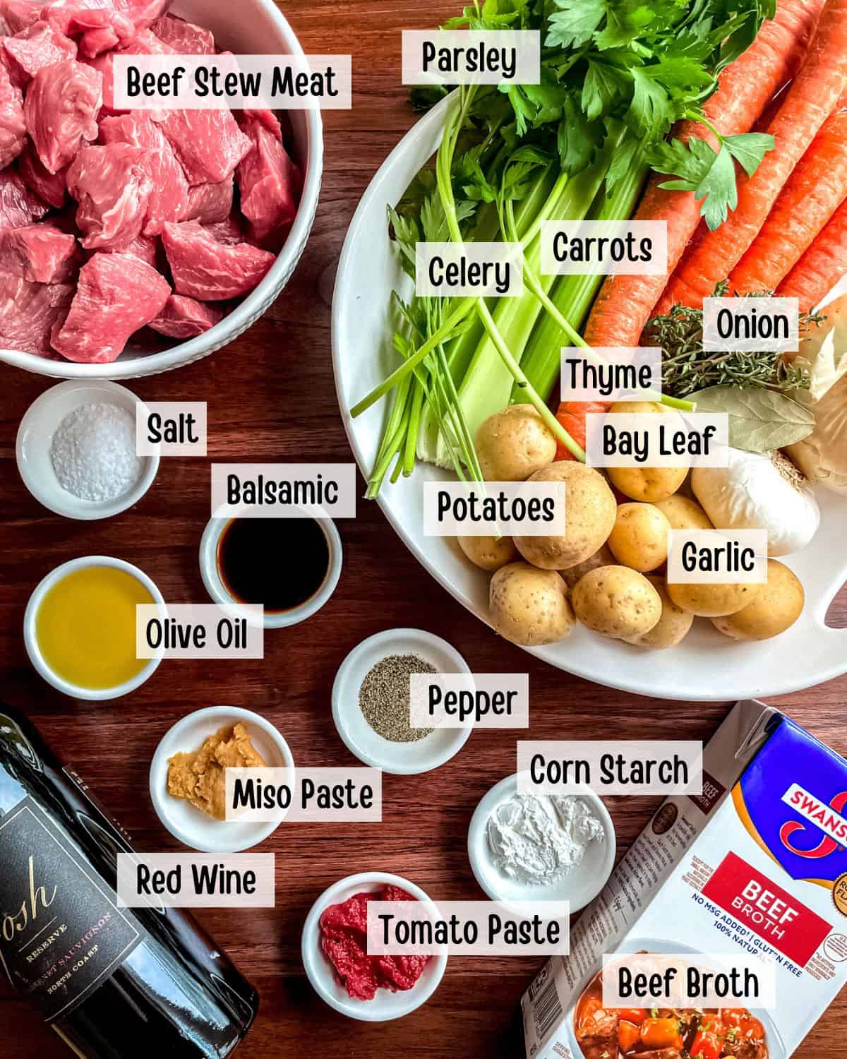 Ingredients needed to make beef stew in a Dutch oven cooking pot.