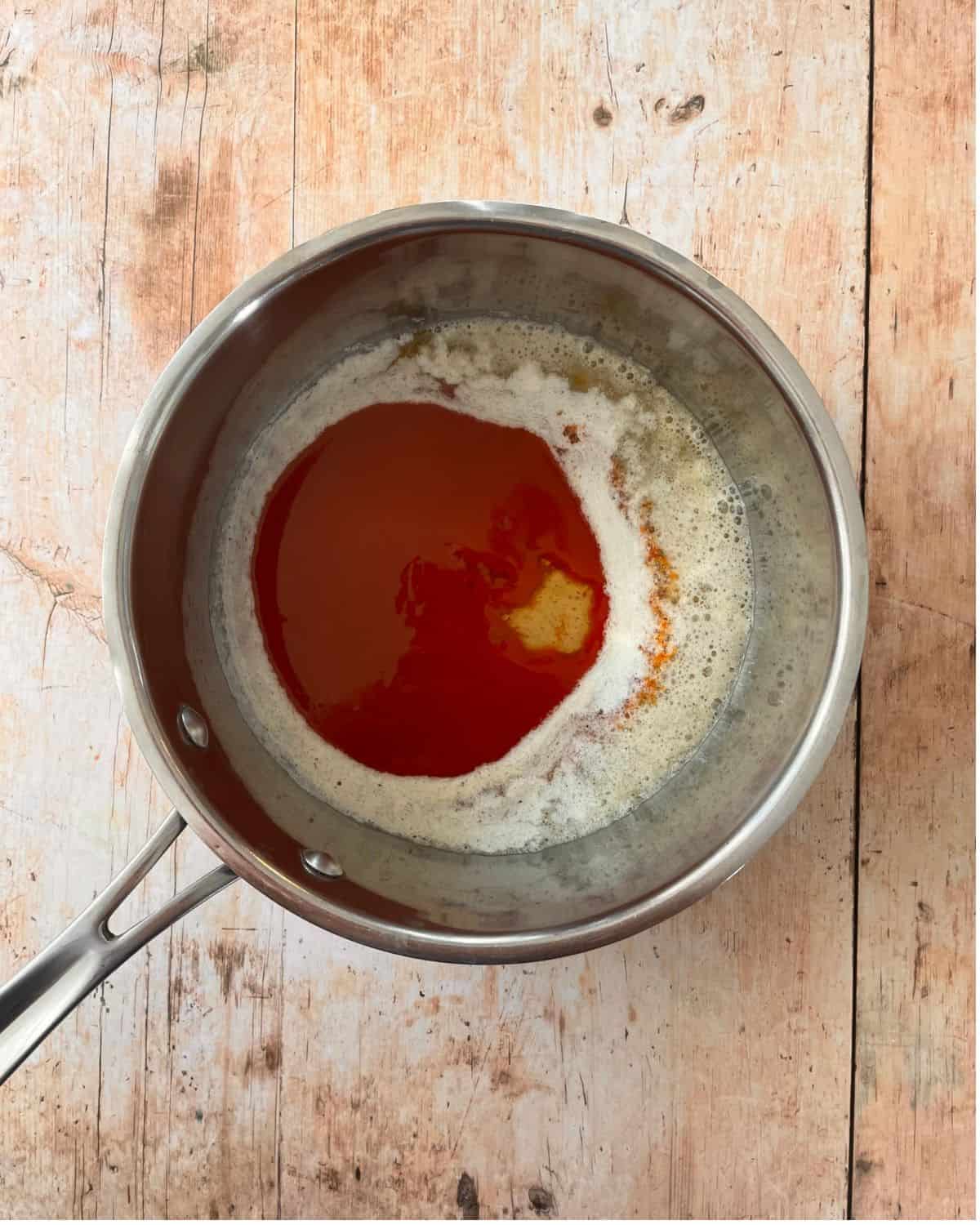 Buffalo sauce, butter, and honey in a saucepan.