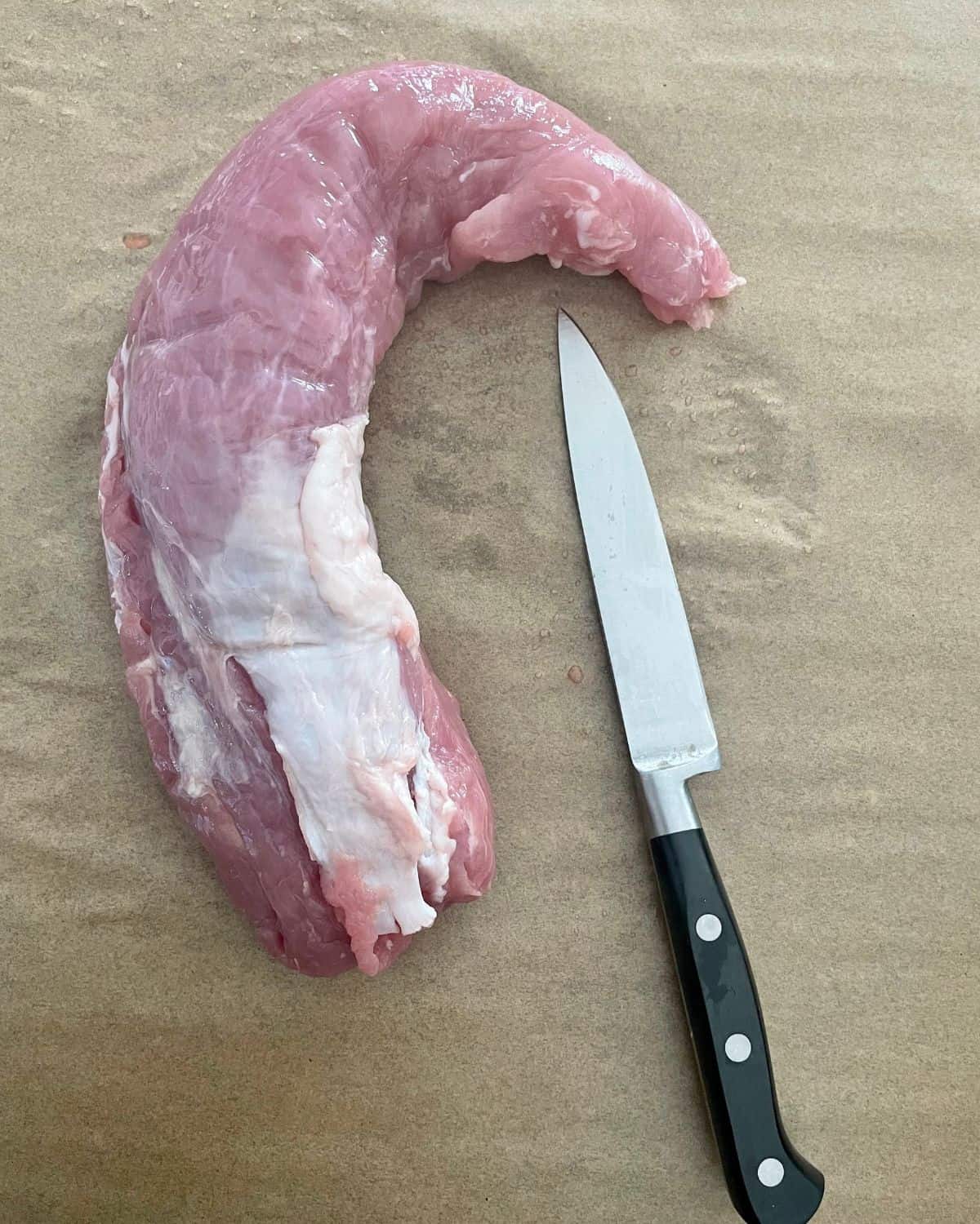 This photo is showing where the silver skin is on a pork tenderloin.