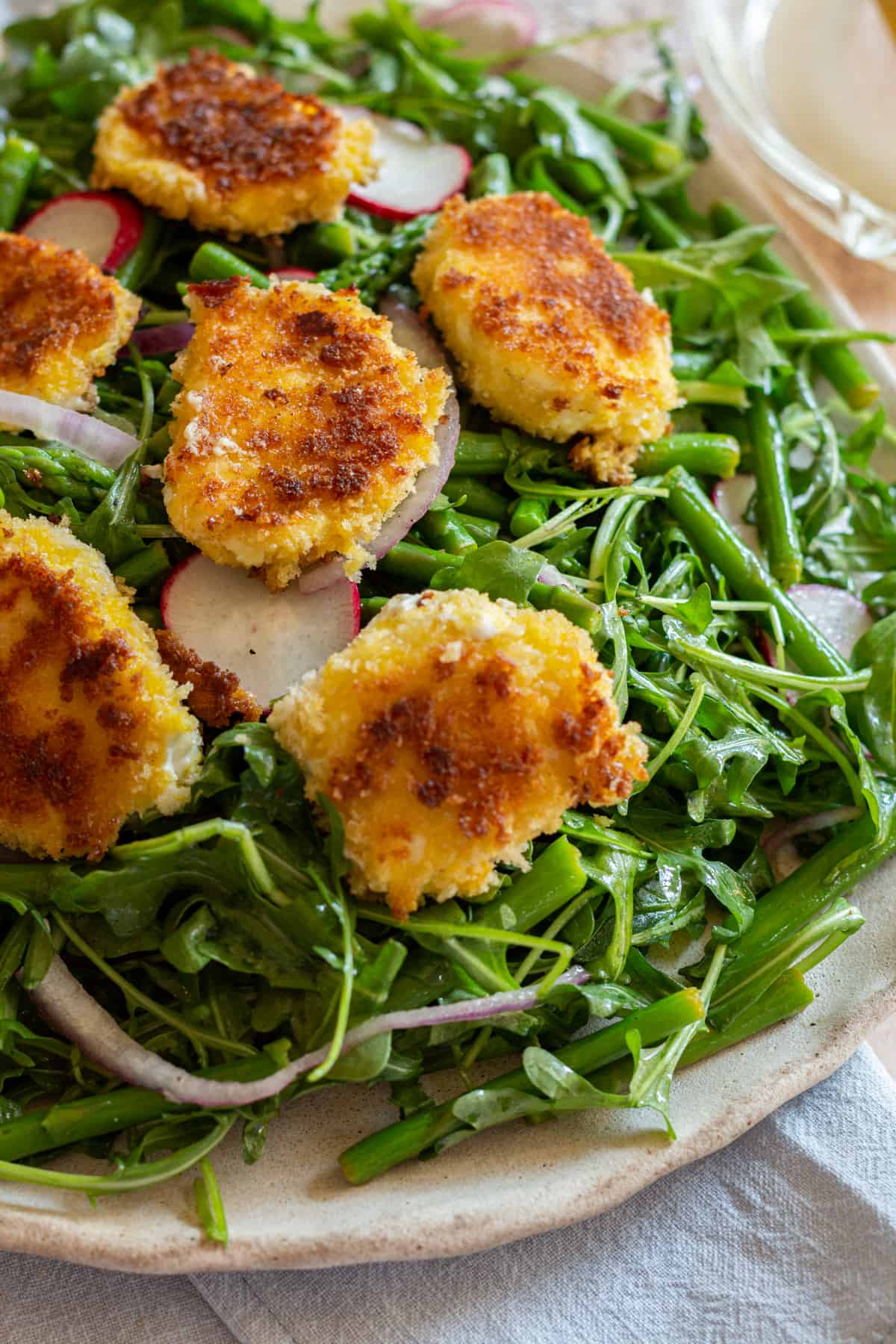 Up close image of the Arugula and Asparagus Salad with fried panko goat cheese rounds.