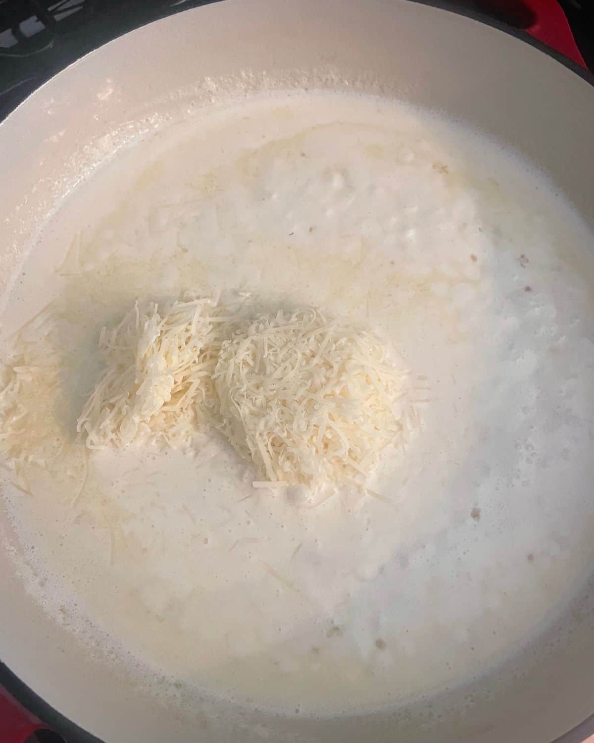 Shredded parmesan cheese added to the heavy cream, white wine, butter, and garlic.
