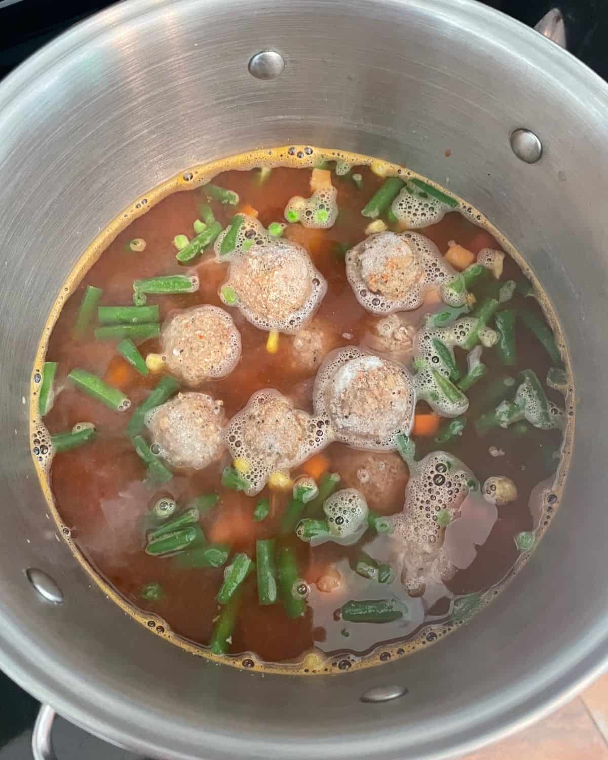 Frozen vegetables and frozen meatballs added to the soup.