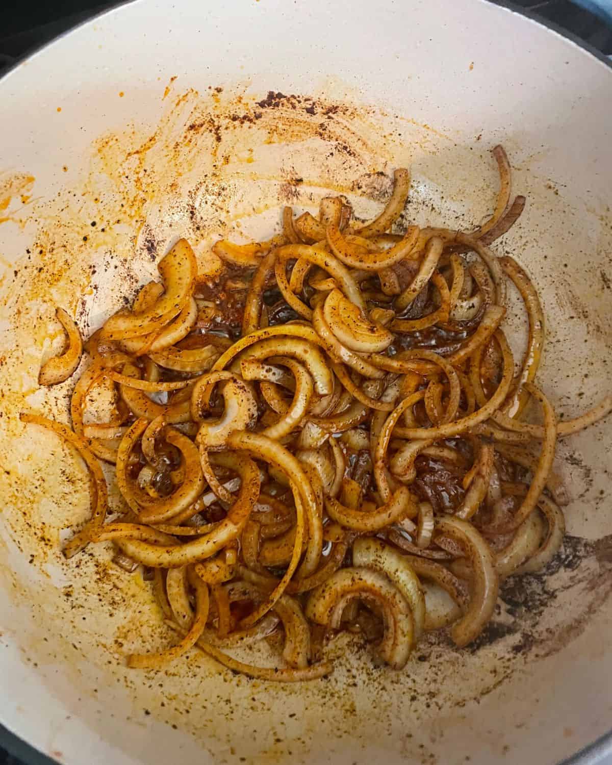 Sliced onions in a Dutch oven cooking.