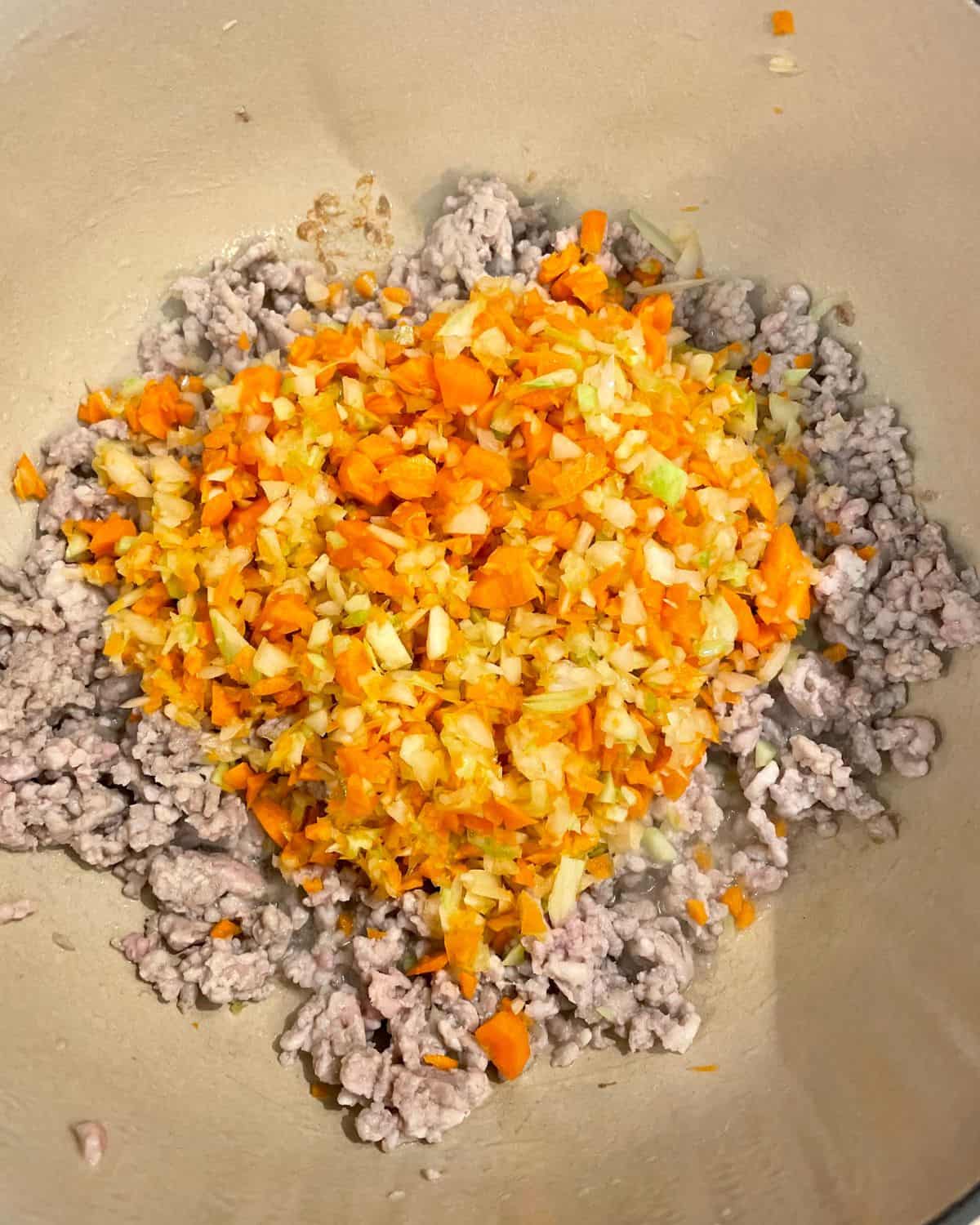 Carrots, onions, and celery added to the ground pork.
