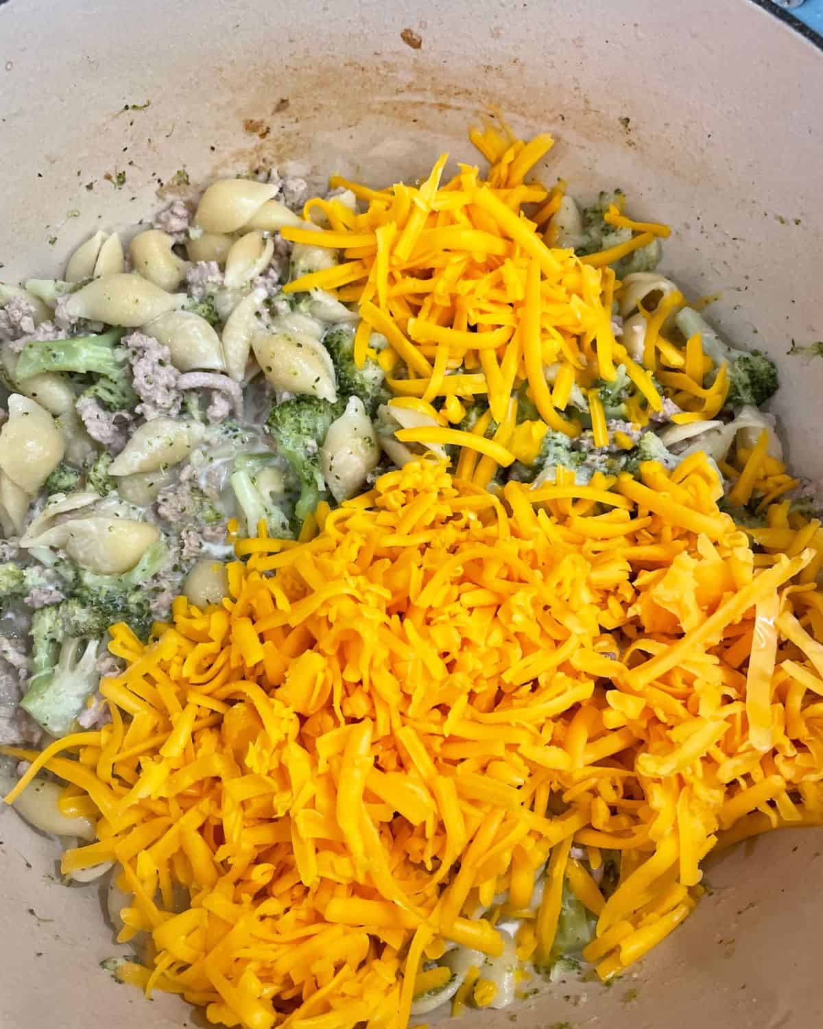 Shredded cheddar cheese added to the ground turkey pasta mixture.