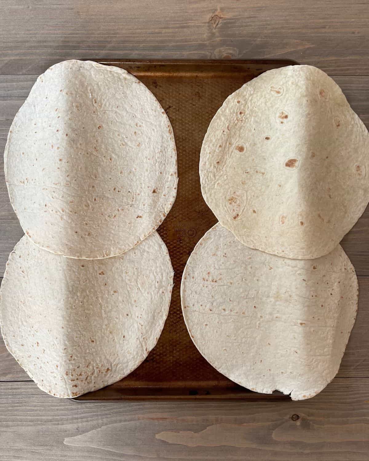 Two tortilla shells on each long edge of the baking sheet.