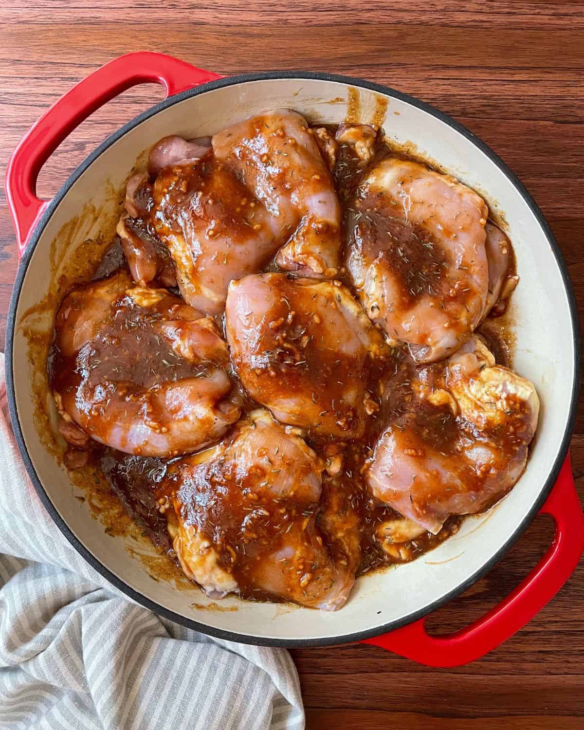 Raw boneless chicken thighs marinating in balsamic marinade.