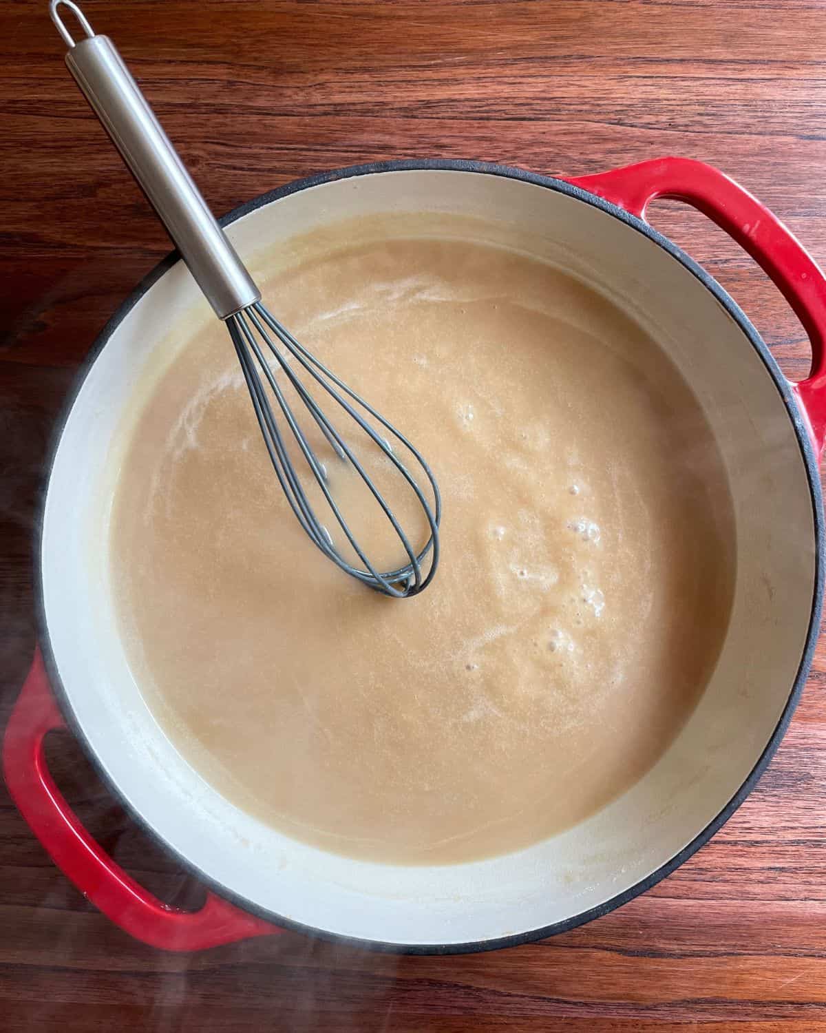 A roux formed in a skillet with a whisk.