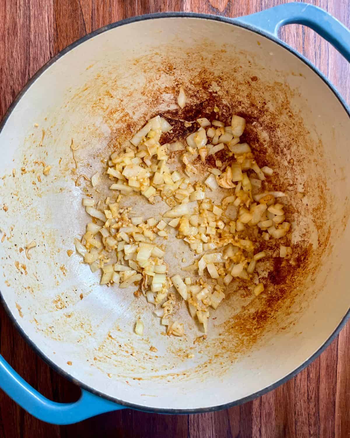 Onion and garlic cooking in a Dutch oven.