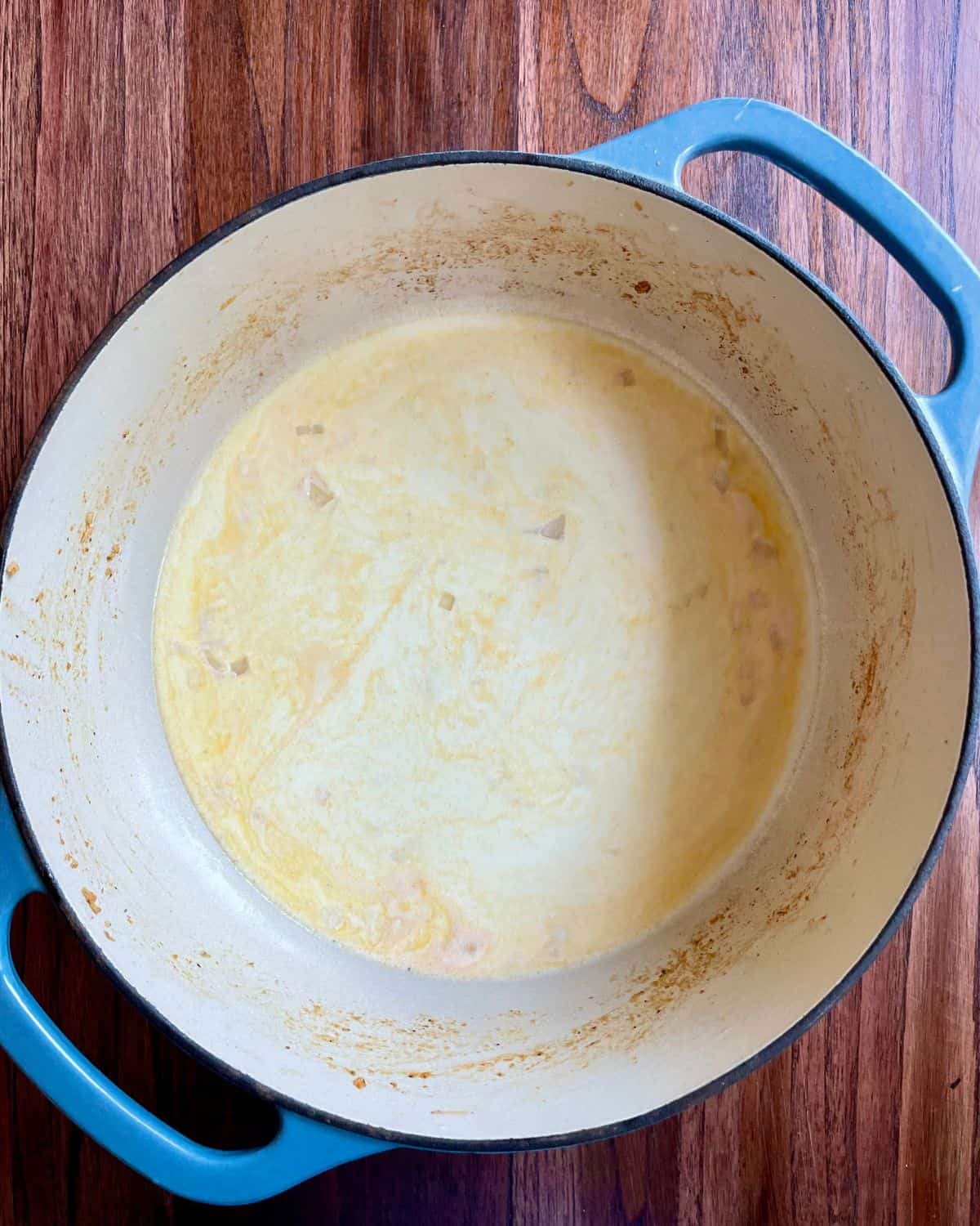 Heavy cream and chicken broth added to the cooking pot.