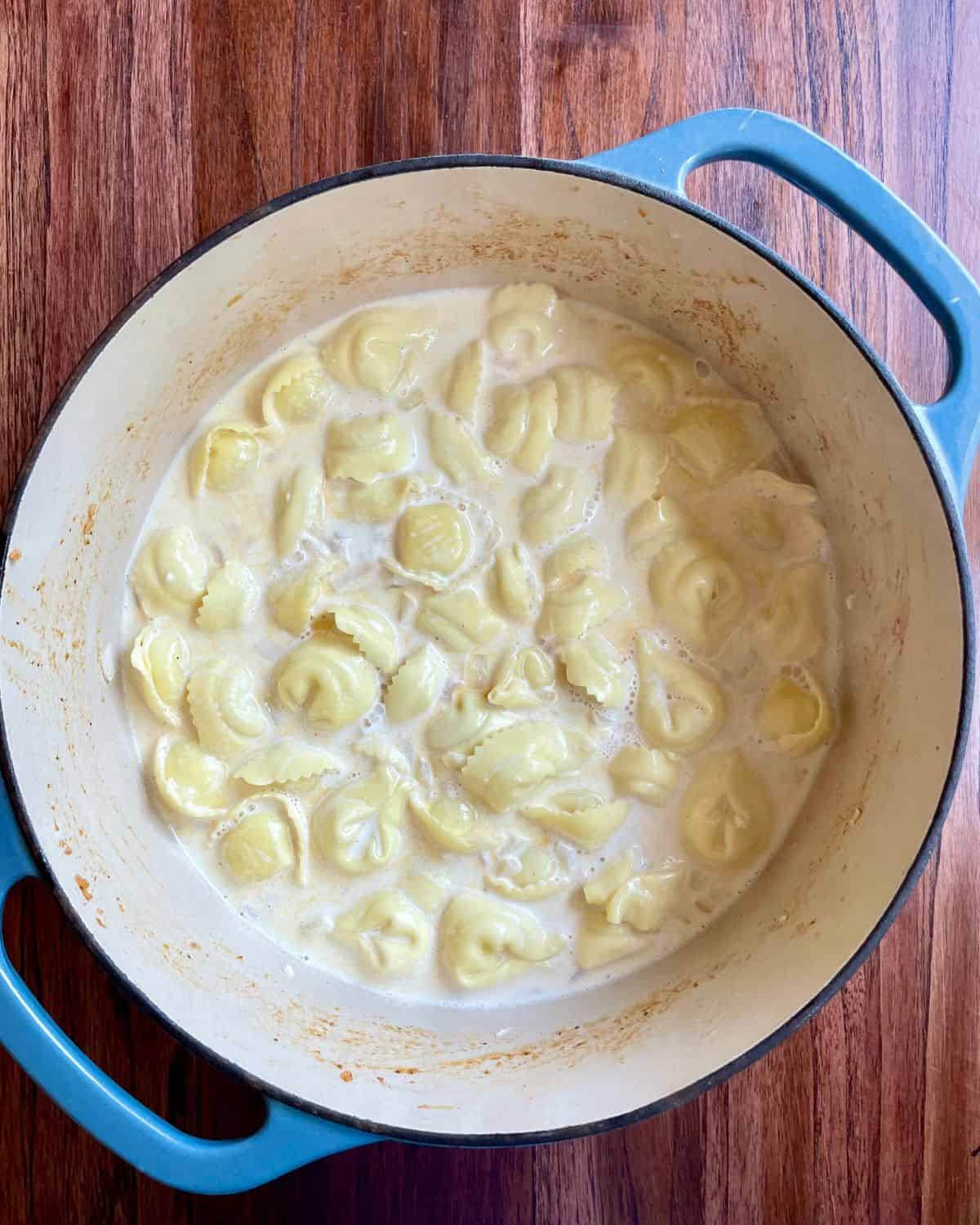 Tortellini cooking in the cream and broth.