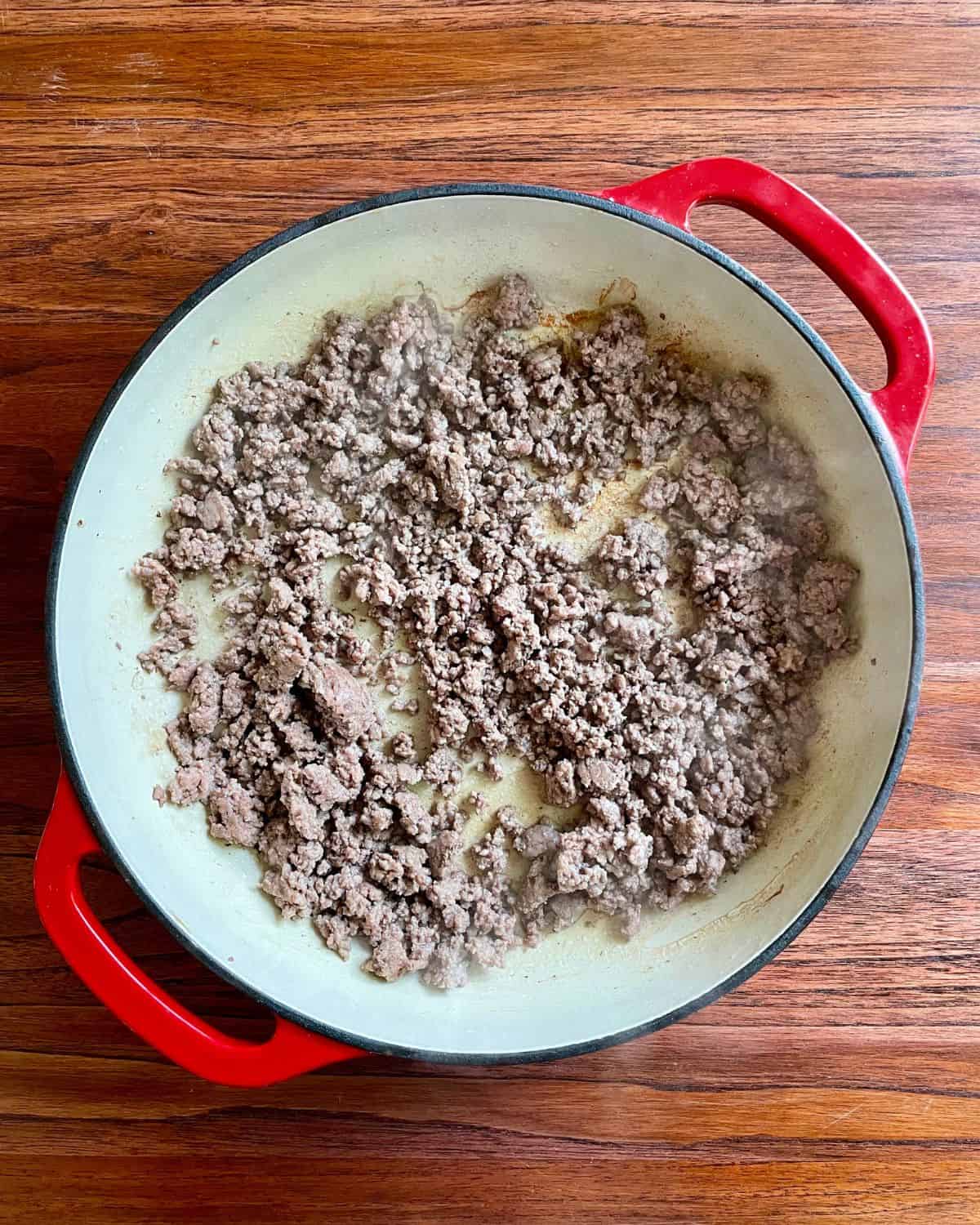 Ground beef cooking in a skillet.