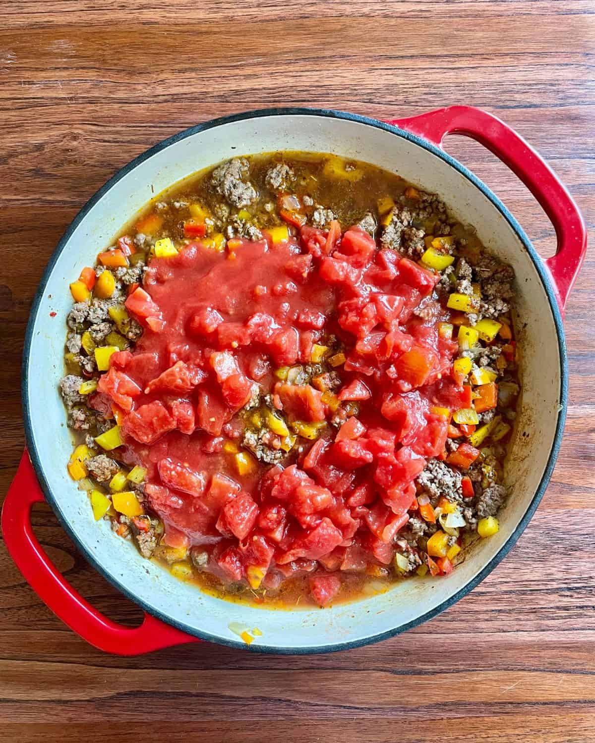 Beef broth, diced tomatoes, and tomato sauce added to the stuffed pepper skillet mixture.