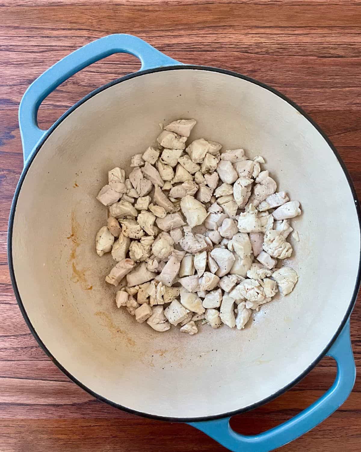 A Dutch oven with diced chicken.