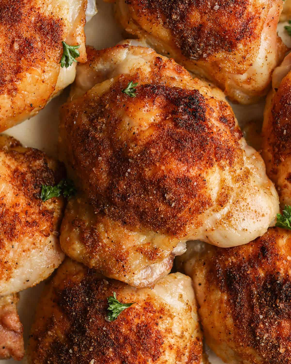 Close up shot of a baked, bone-in chicken thigh.