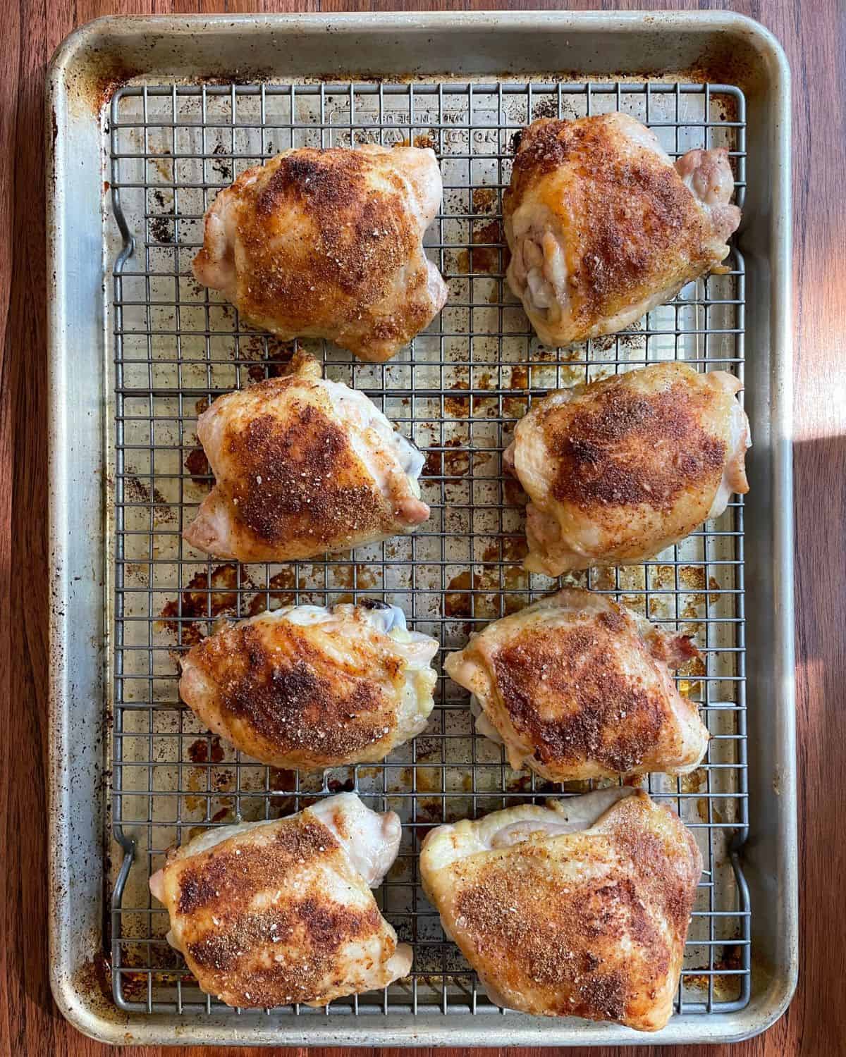 Seasoned bone-in chicken thighs after they have baked and just been pulled out of the oven.