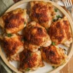 A plate of oven-baked chicken thighs, ready to serve.