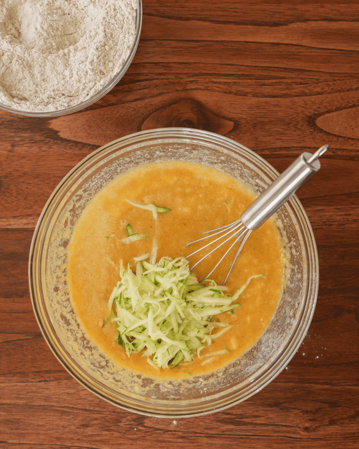 The bowl of wet ingredients combined with the shredded zucchini.