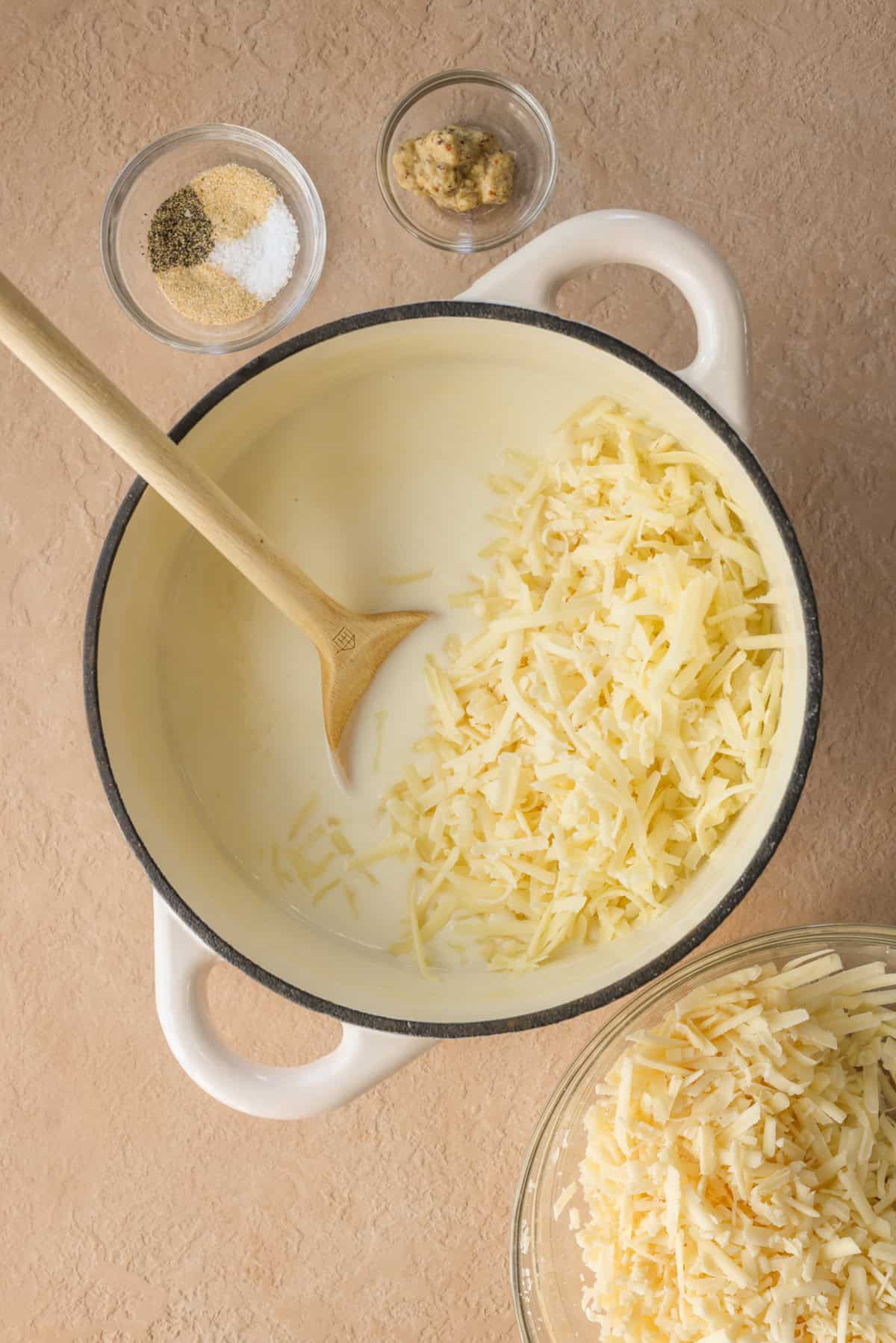 Cheese sauce with shredded cheese getting mixed in.