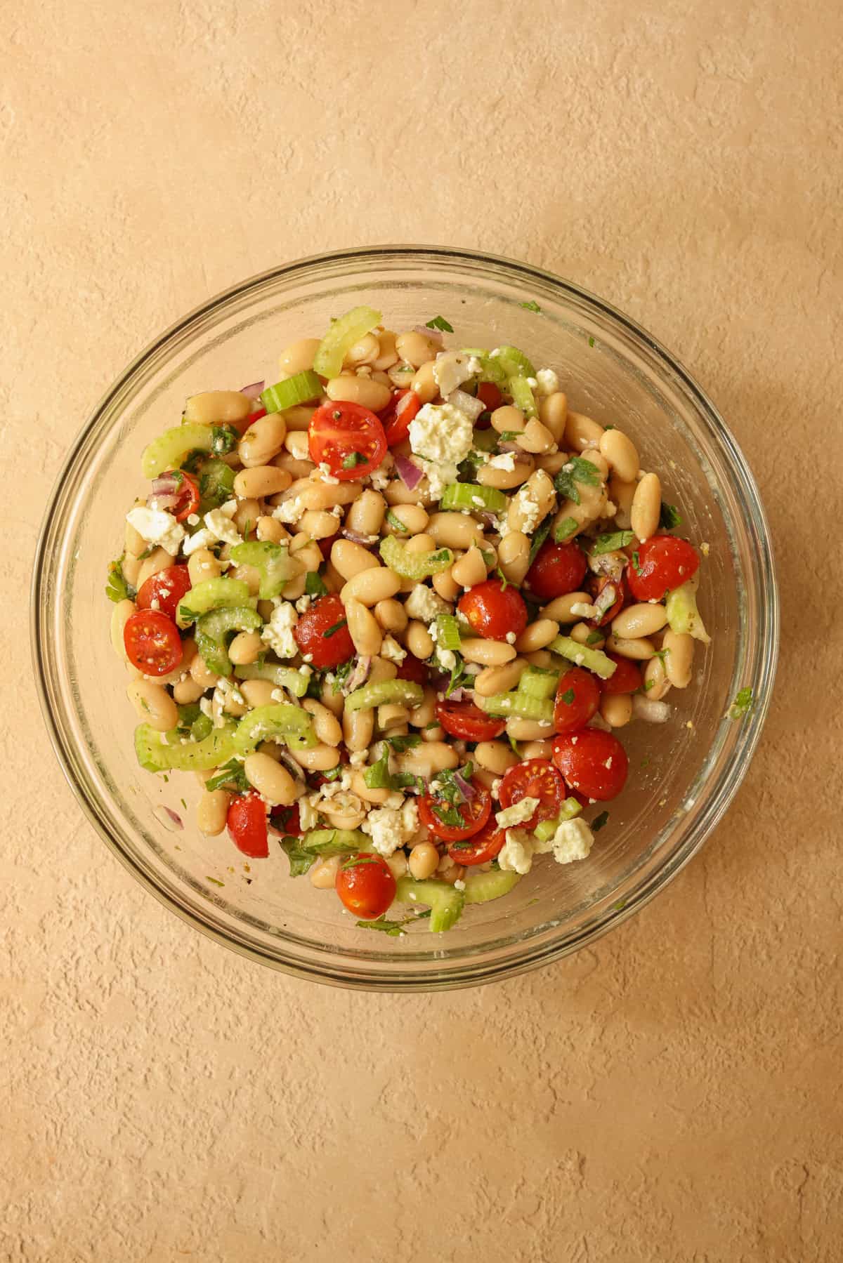 The feta cheese is gently mixed in, and the Mediterranean white bean salad is ready to serve.
