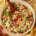 A close-up image of the Greek white bean salad in a white serving bowl.