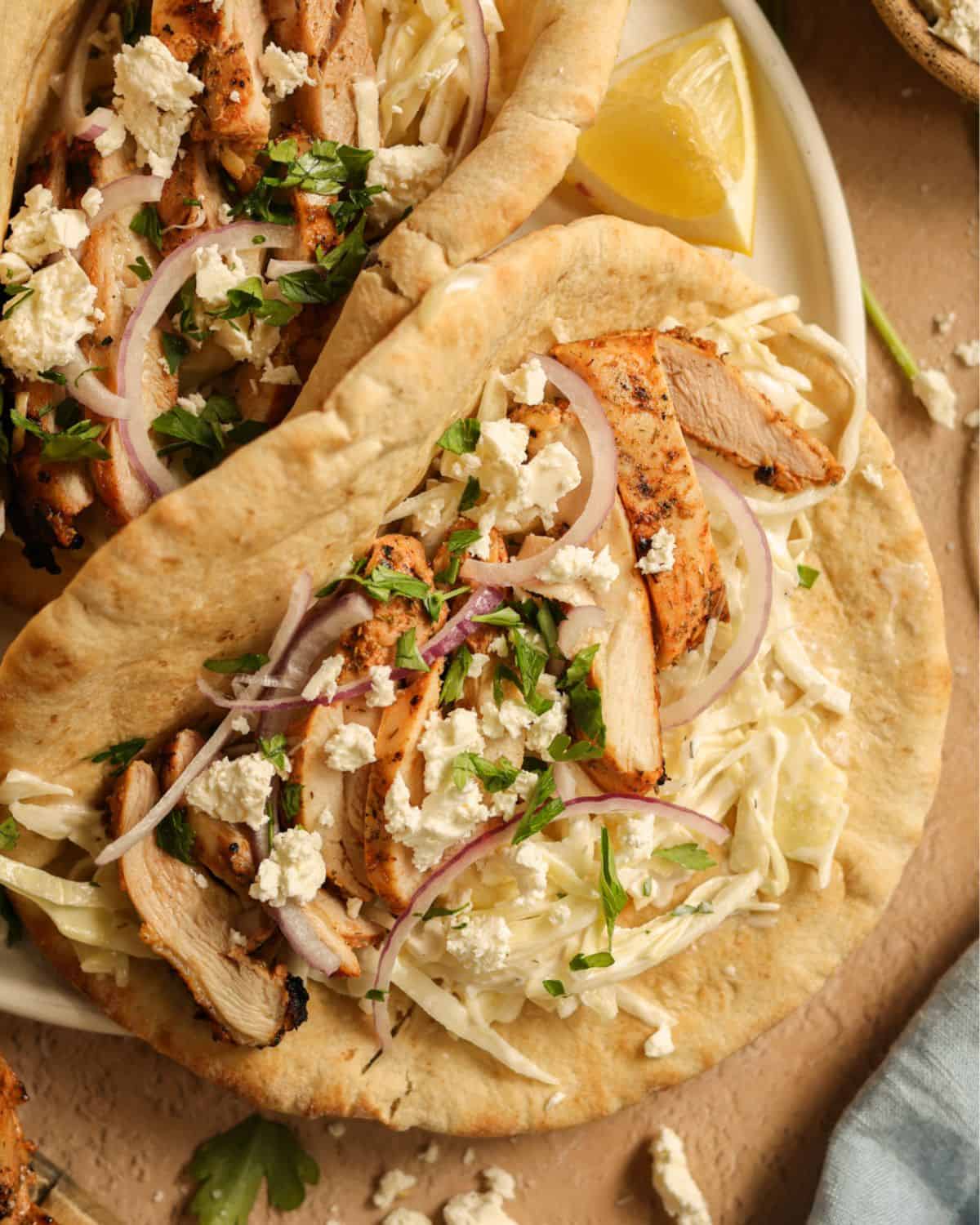 Grilled chicken pitas stuffed with Tzatziki slaw, red onions, and feta cheese.