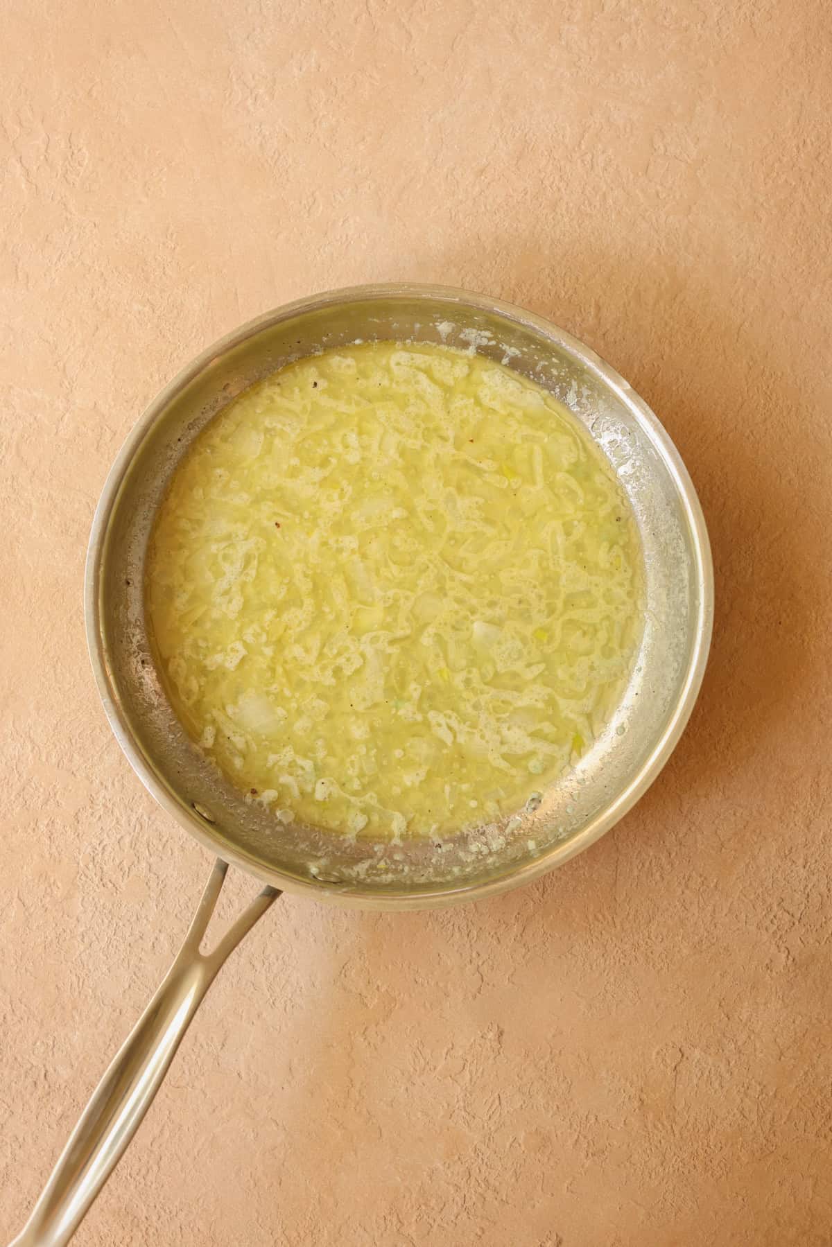 Lemon butter sauce in a skillet.