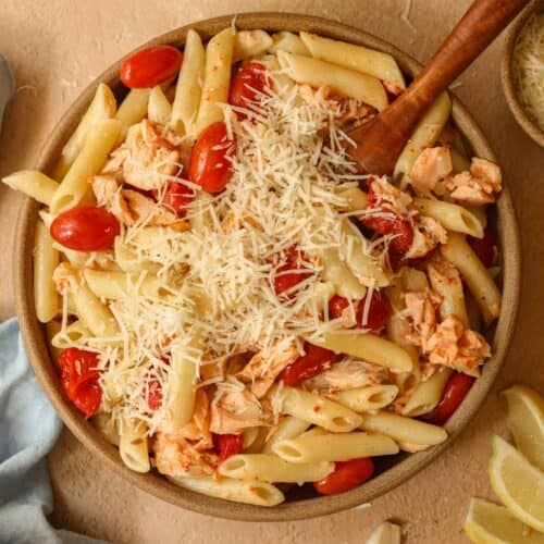 Flaked salmon pasta without cream in a dish along with roasted cherry tomatoes.