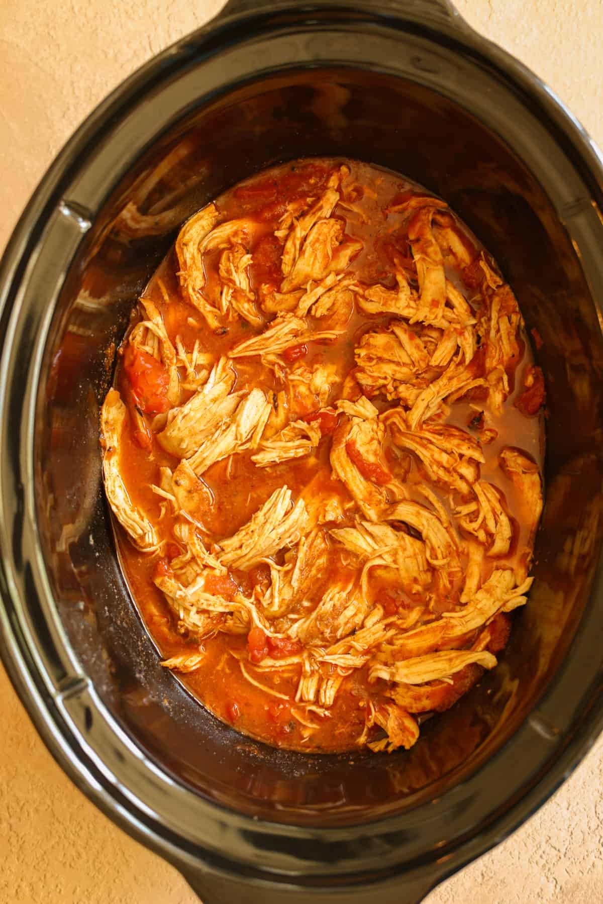 Shredded chicken in a slow cooker.