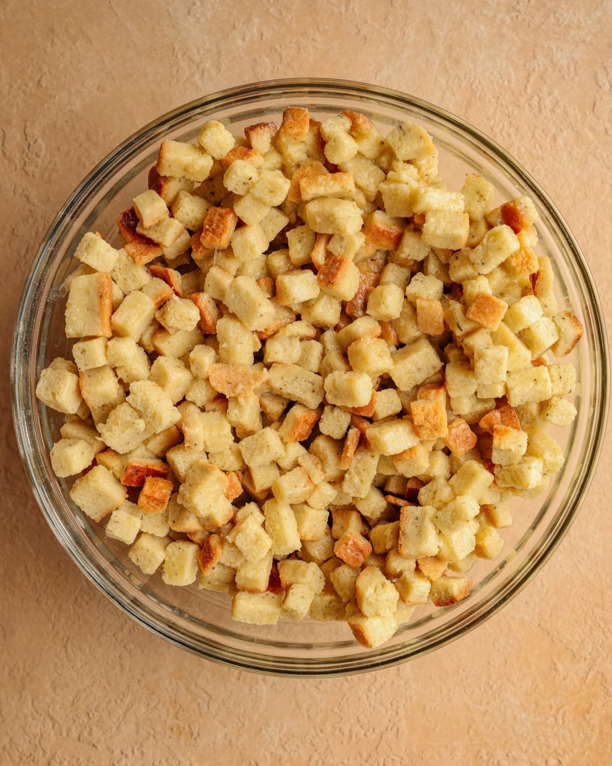 Stuffing mix tossed with broth, butter, and eggs, in a bowl.