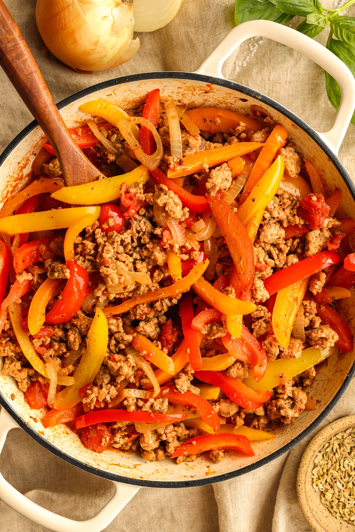 Ready to serve ground pork sausage and peppers in a skillet. Various garnishes are shown around the image.