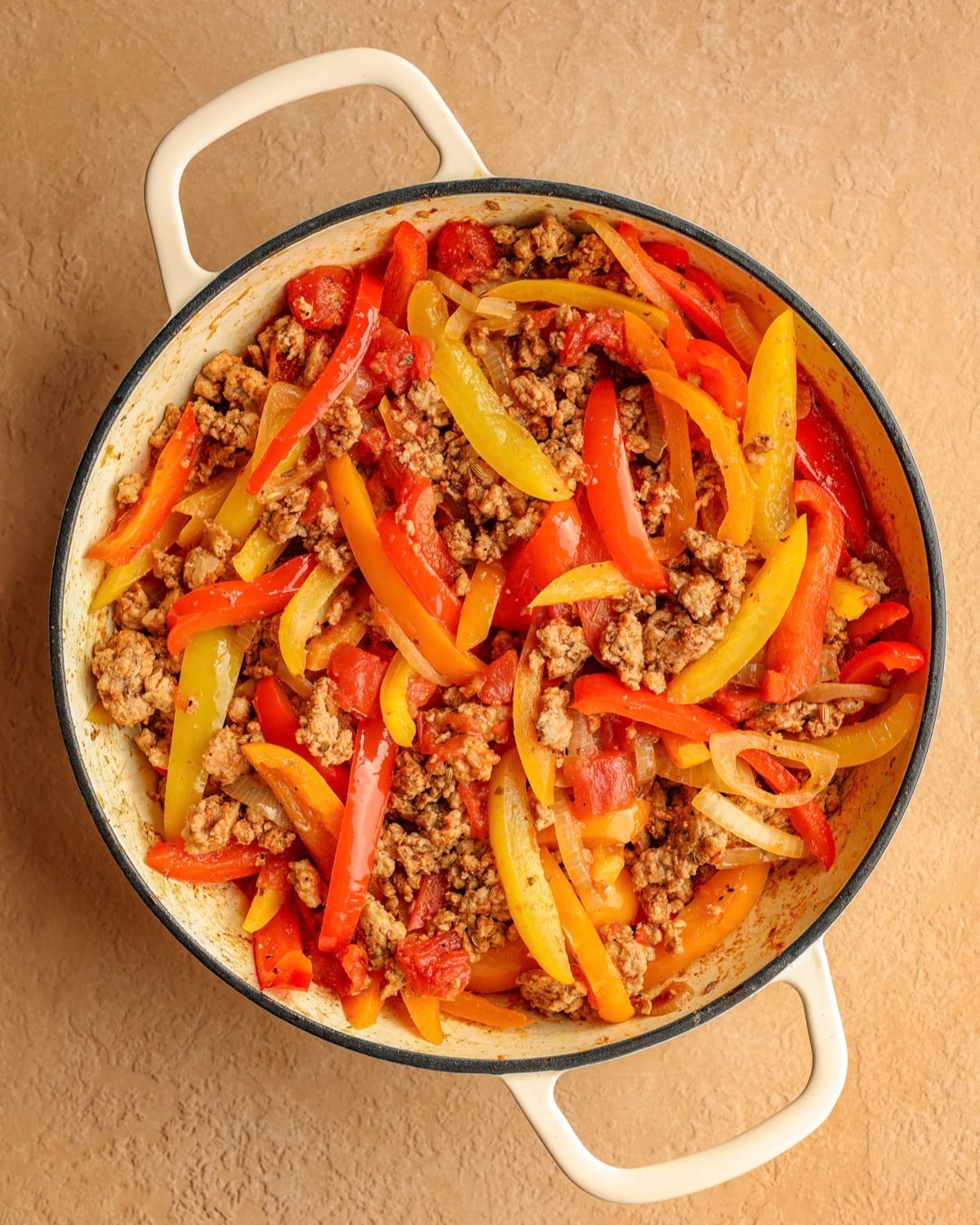 Ground pork sausage added back into the skillet with the peppers, onions, and tomatoes.