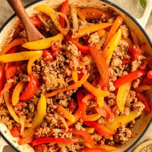Cooked ground pork sausage and peppers in a skillet.