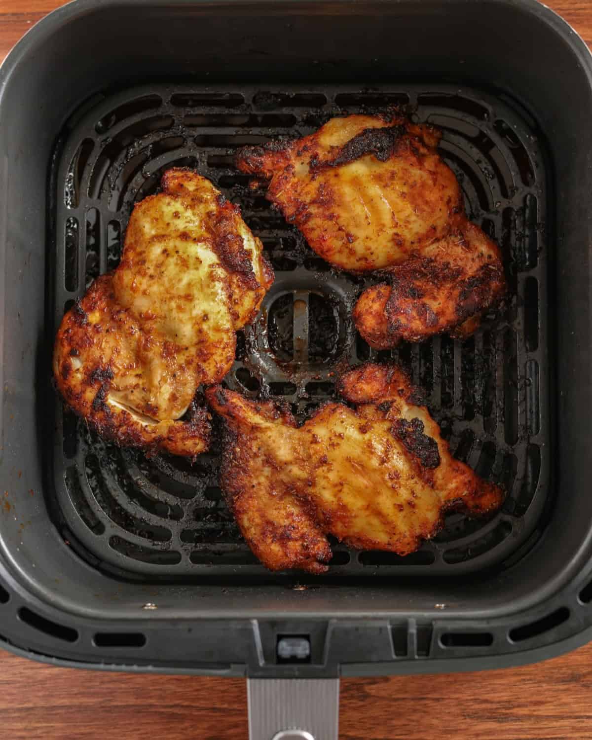 Fully-cooked chicken thighs in an air fryer.